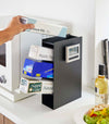 Side-view of black steel four-tiered food wrap stand.