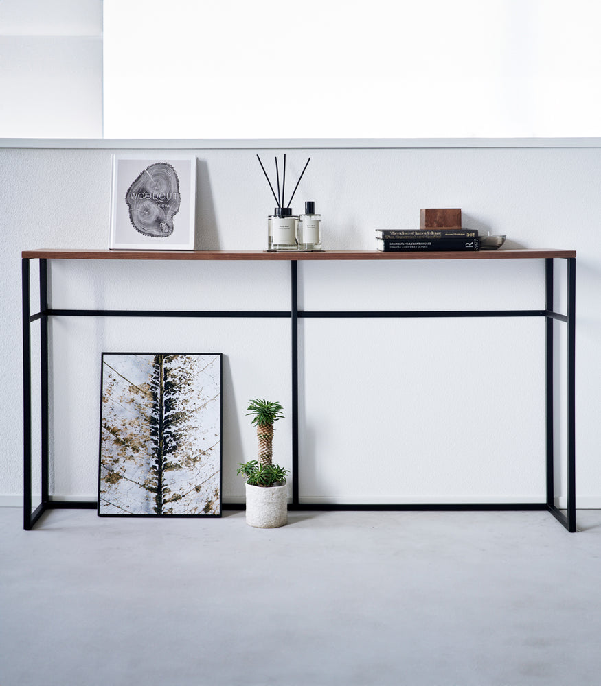 View 15 - Straight view of the Long Console Table by Yamazaki Home in black with decorative items.