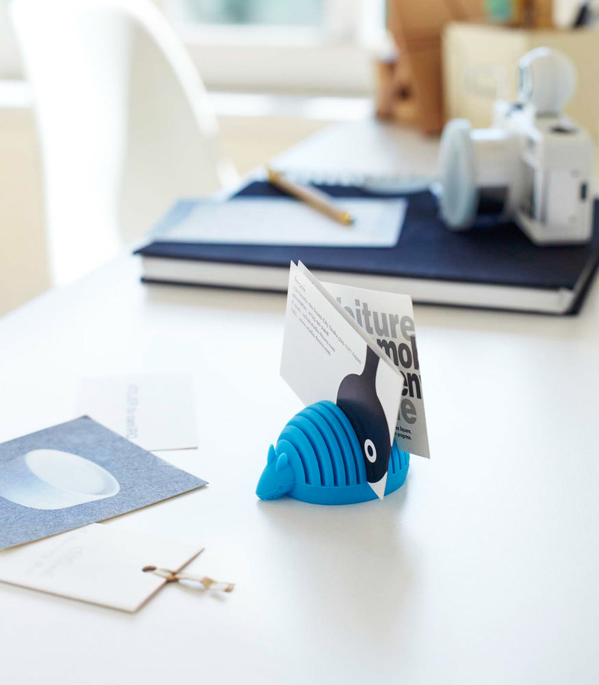 View 2 - Blue Armadillo Business Card Holder holding cards on desk by Yamazaki Home.