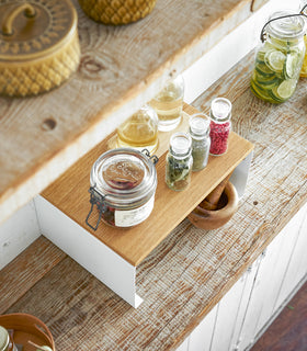Aerial view of white Stackable Countertop Shelf holding spices on kitchen counter by Yamazaki Home. view 10