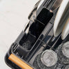 Removable utensil holder holding three forks on a black dish drying rack with wood handles in a modern kitchen.