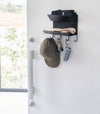 Magnetic Entryway Rack by Yamazaki Home in black mounted on a door storing various entryway items.