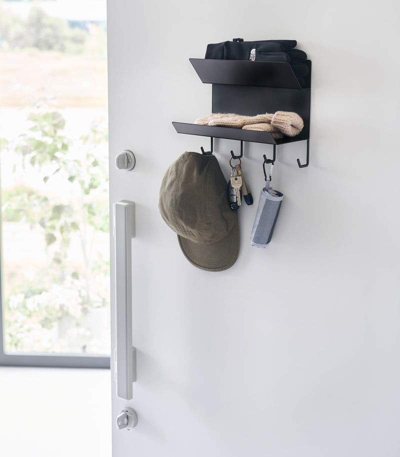 Magnetic Entryway Rack by Yamazaki Home in black mounted on a door storing various entryway items.