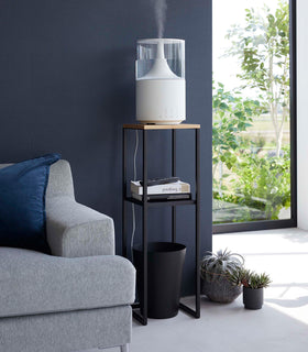 Yamazaki black Pedestal Stand in a living room with an air purifier on top and books on the lower shelf view 10