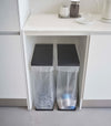 Two Black Yamazaki Home Lidded Garbage Bag Holder under a shelf
