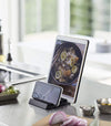 Black Phone and Tablet Stand holding phone and tablet on kitchen counter by Yamazaki Home.