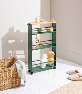 Forest Green Yamazaki Home Slim Storage Cart storing bathroom accessories view 2