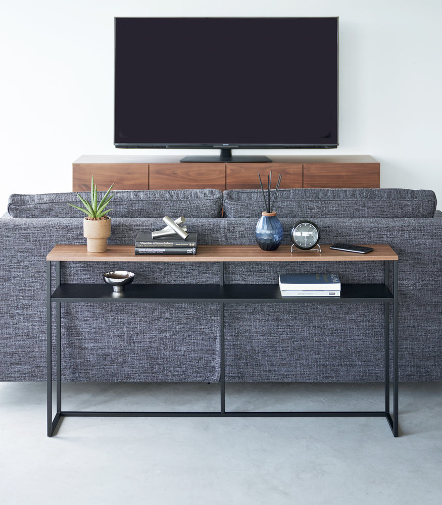 View 28 - Frontal image of black Yamazaki Home Long Console Table - Shelf with books and decorations on it