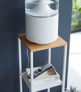 Closeup of Yamazaki white Pedestal Stand with an air purifier on top and books on the lower shelf view 6