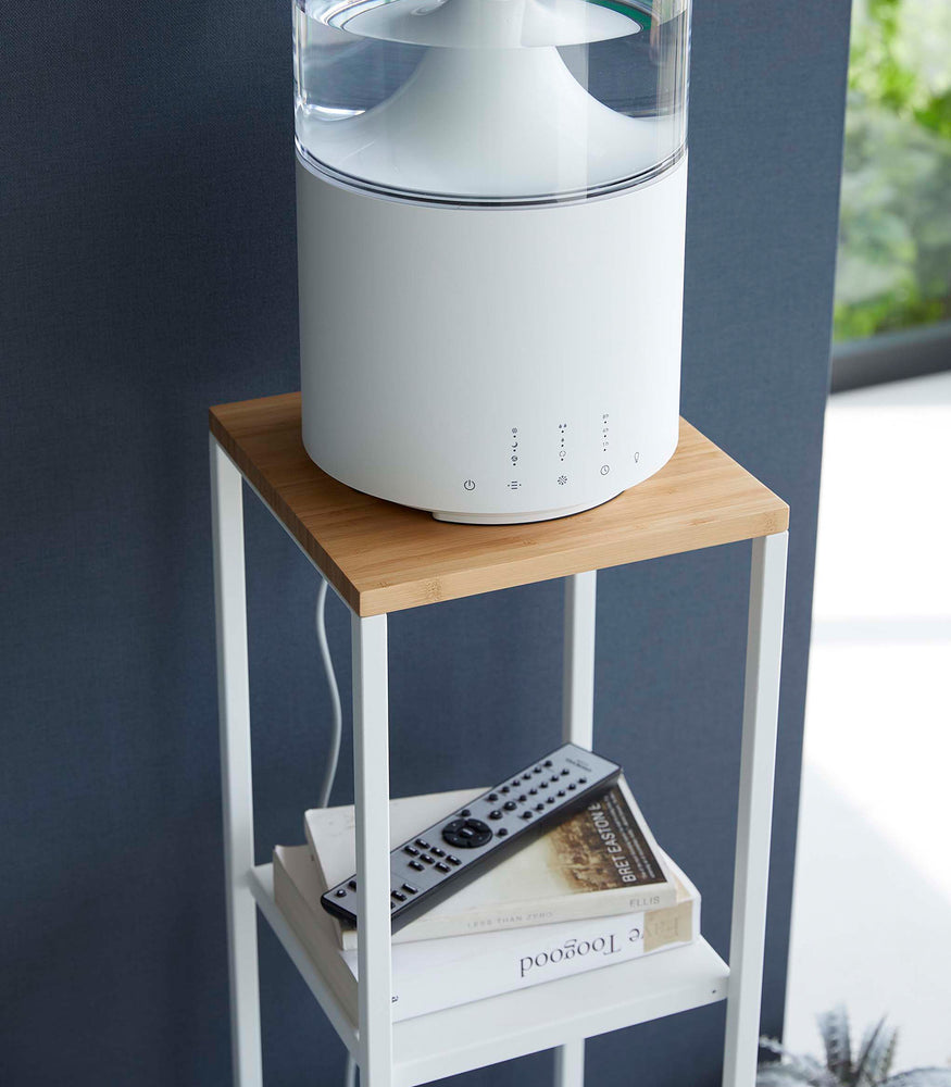 View 6 - Closeup of Yamazaki white Pedestal Stand with an air purifier on top and books on the lower shelf