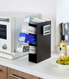 Side-view of black steel four-tiered food wrap stand.