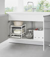 Yamazaki Home White Three-Tier Cabinet Storage Rack holding pot and pans under the sink.