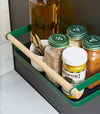Close up top-down view of Forest Green Yamazaki Home Magnetic Storage Caddy with oil, herbs and spices stored attached to a refridgerator