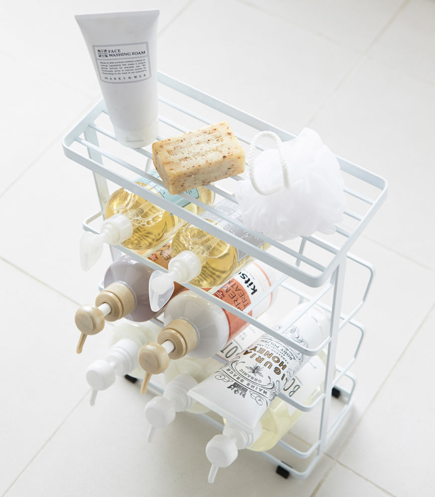 View 9 - Aerial view of white Freestanding Shower Caddy holding beauty products in bathroom by Yamazaki Home.