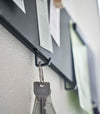 Closeup of Yamazaki black Magnetic Wall Panel with a key hanging from a hook