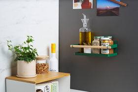 Wide shot of Forest Green Yamazaki Home Magnetic Storage Caddy with oil, herbs and spices stored attached to a refridgerator view 3