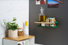 Wide shot of Forest Green Yamazaki Home Magnetic Storage Caddy with oil, herbs and spices stored attached to a refridgerator