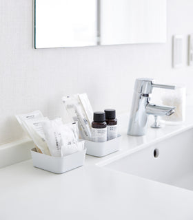 Small white Accessory Trays holding beauty products on bathroom sink counter by Yamazaki Home. view 2