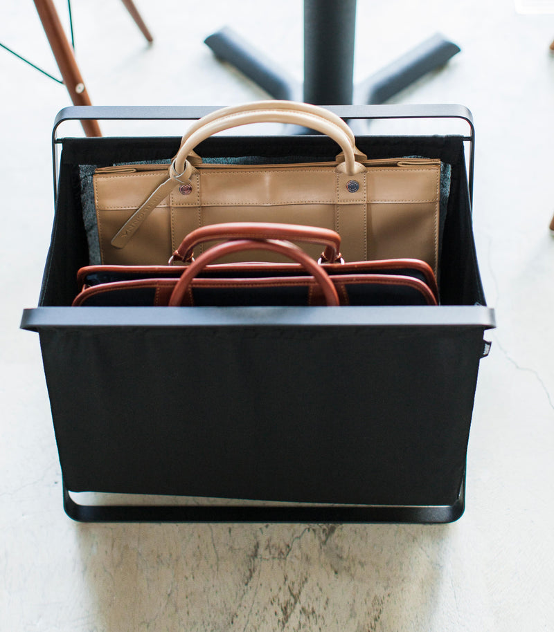 Aerial front view of black Storage Hamper holding bags by Yamazaki Home.