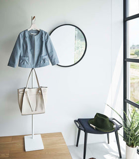 White Yamazaki Coat Rack in an entryway with a jacket and purse hung on it view 4
