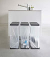 Three Black Yamazaki Home Lidded Garbage Bag Holder filled with different recyclables
