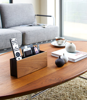 Walnut Organizer Caddy holding phone, remote, and glasses on coffee table by Yamazaki Home. view 7