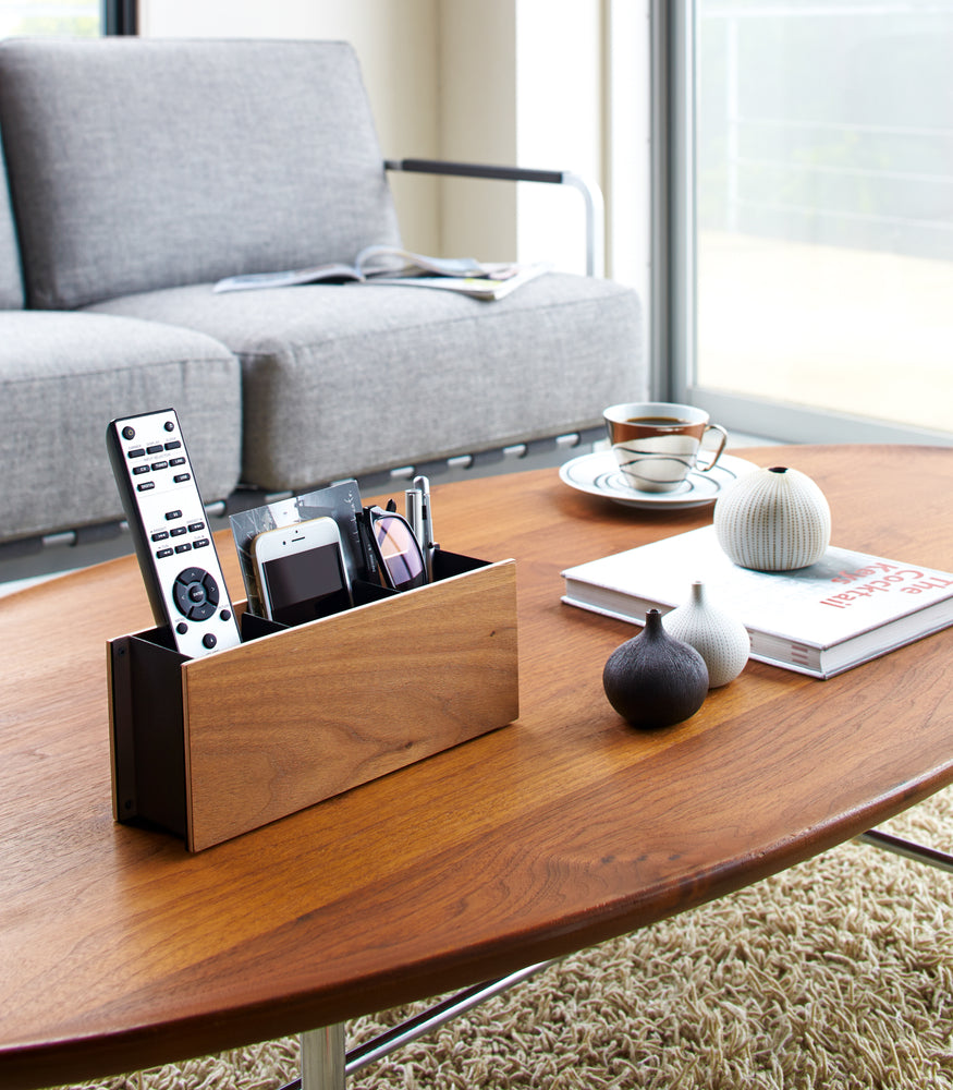 View 7 - Walnut Organizer Caddy holding phone, remote, and glasses on coffee table by Yamazaki Home.