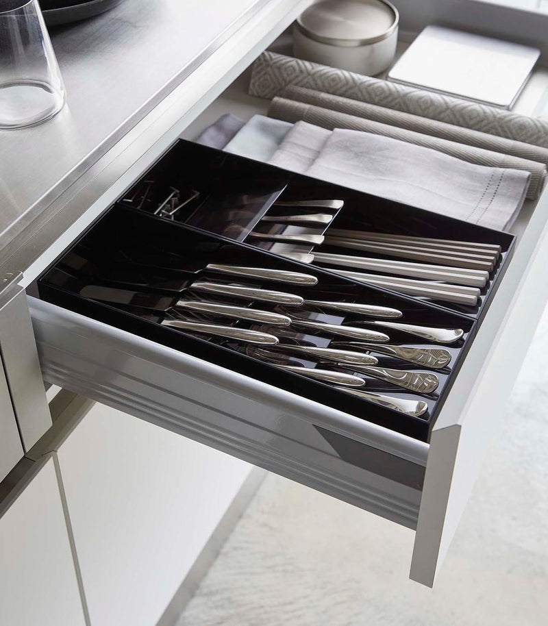 Two black Cutlery Storage Organizers holding silverware in kitchen drawer by Yamazaki Home.