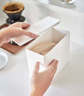 Opening white Yamazaki Home kitchen storage box storing coffee filters view 5