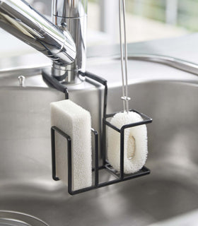 Black Steel Yamazaki Home Faucet-Hanging Sponge & Brush Holder holding a brush and a sponge view 15