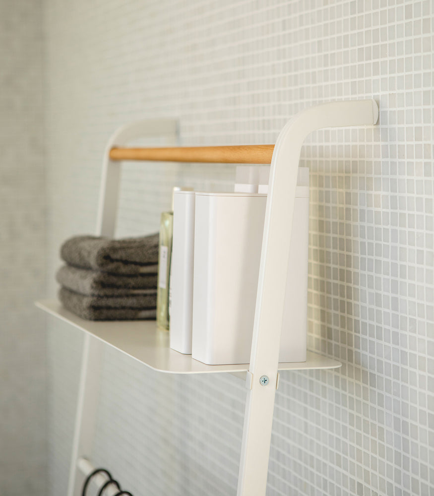 View 12 - Close up side view of white Leaning Ladder Rack holding towels and containers in bathroom by Yamazaki Home.