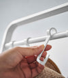 Close up of hooks being placed on white Yamazaki Home Coat Rack with Hat Storage