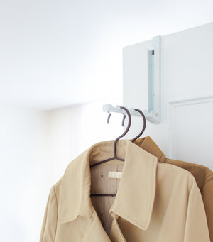 White Over-the-Door Hanger displaying jackets on door by Yamazaki Home.