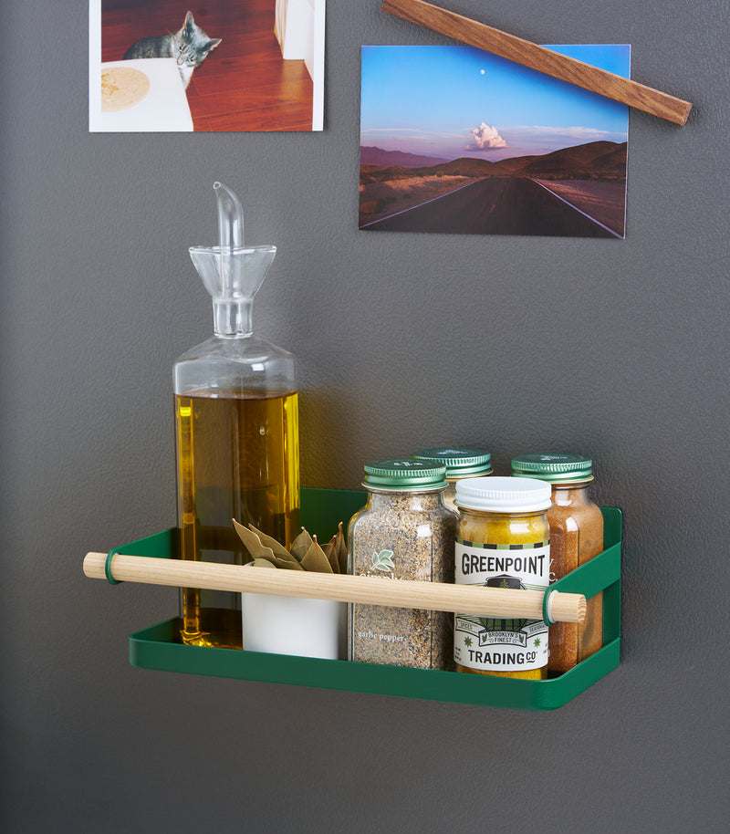 Forest Green Yamazaki Home Magnetic Storage Caddy with oil, herbs and spices stored attached to a refridgerator