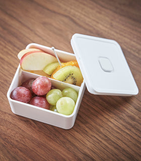 Close up aerial view of white Vacuum-Sealing Bento Box with cover ajar holding fruit by Yamazaki Home. view 4