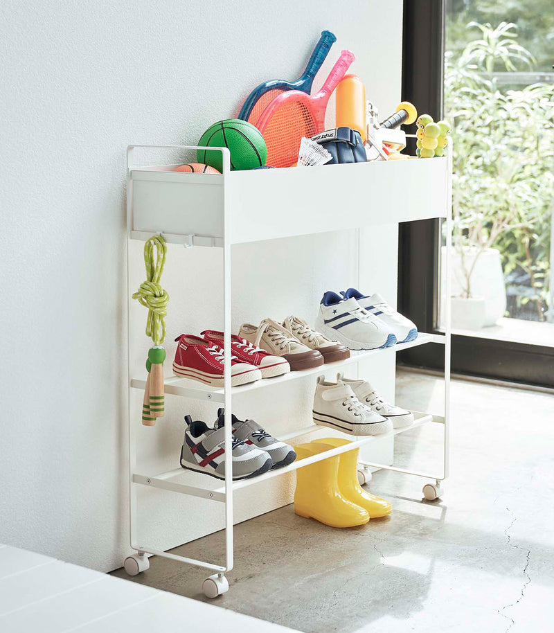 White Yamazaki Entryway Organizer with shoes and toys on it