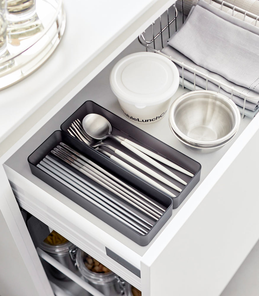 View 41 - Two large stackable clear organizers in black are placed in a kitchen drawer, organizing cutlery, neatly placed next to each other