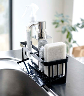 Profile of black steel sponge and soap bottle holder with white draining tray. view 15