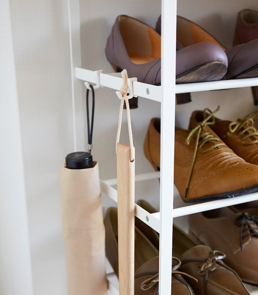 View 6 - Close up view of Shoe Rack holding shoes and umbrella by Yamazaki Home.