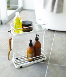White Shower Caddy holding cleaning items in bathroom by Yamazaki Home. view 3