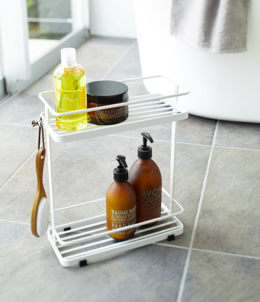 View 3 - White Shower Caddy holding cleaning items in bathroom by Yamazaki Home.