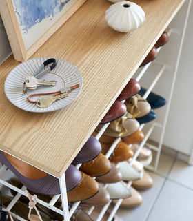 Close up view of white Shoe Rack holding shoes and keys in entryway by Yamazaki Home. view 5