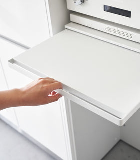 A hand pulling the shelf out on the Countertop Drawer with Pull-Out Shelf by Yamazaki Home in white. view 5