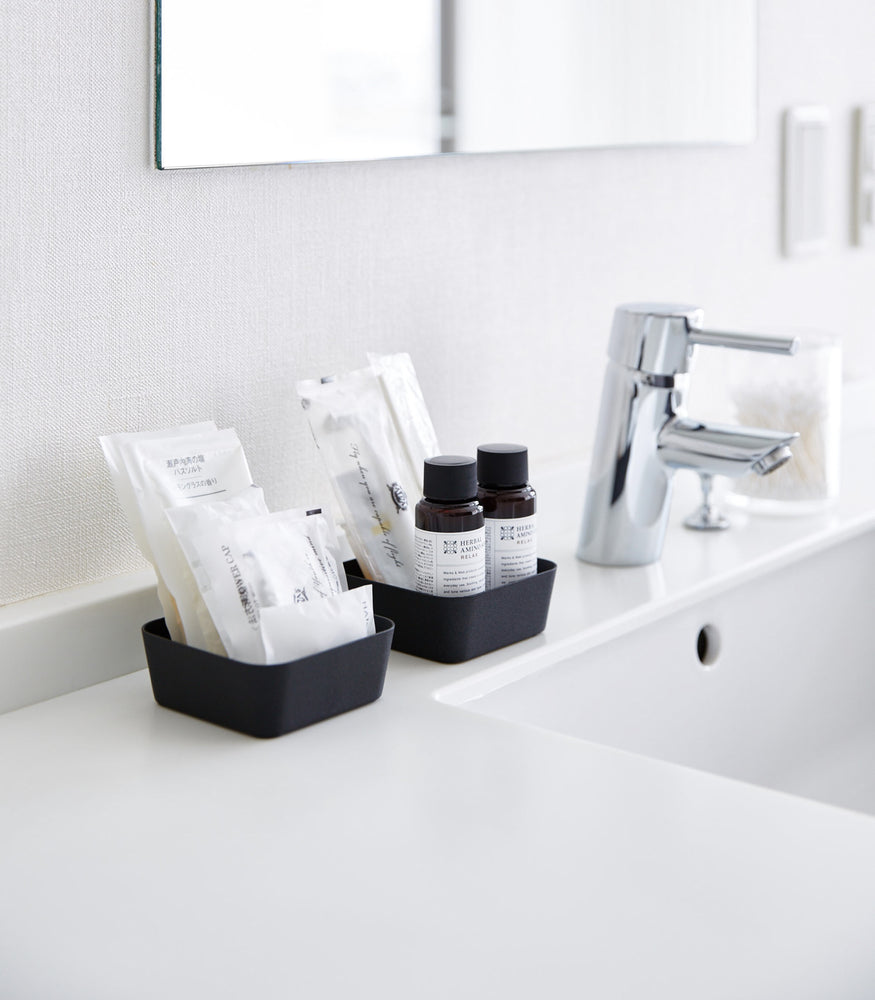 View 7 - Small black Accessory Trays holding beauty items on bathroom sink counter by Yamazaki Home.