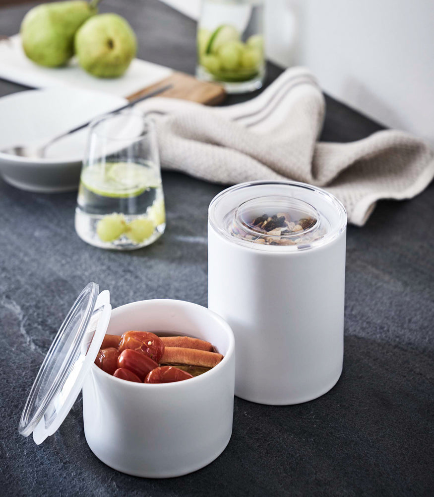 View 13 - Close up view of white Ceramic Canisters holding pickles and granola by Yamazaki Home.