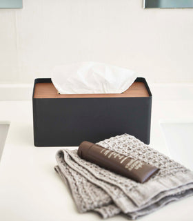 Front view of Yamazaki Home black Tissue Case holding tissues on bathroom countertop.  view 23