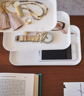 Top-down view of Yamazaki Home White Rin Series 3-Tiered Accessory Tray with accessories displayed such as a watch or phone view 7