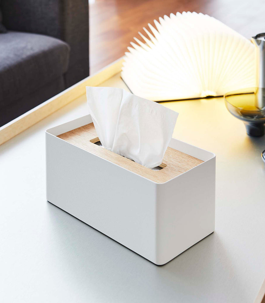 View 3 - White Tissue Case next to book light on coffee table by Yamazaki Home.