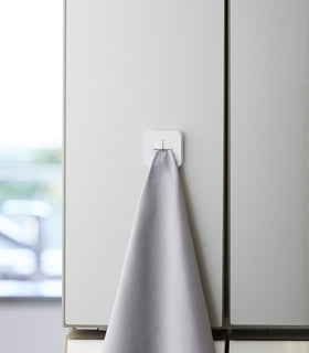 Frontal view of white Yamazaki Home Traceless Adhesive Towel Holder view 4