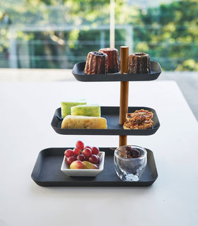 Side view of Yamazaki Home Black Rin Series 3-Tiered Accessory Tray with various desserts displayed view 15